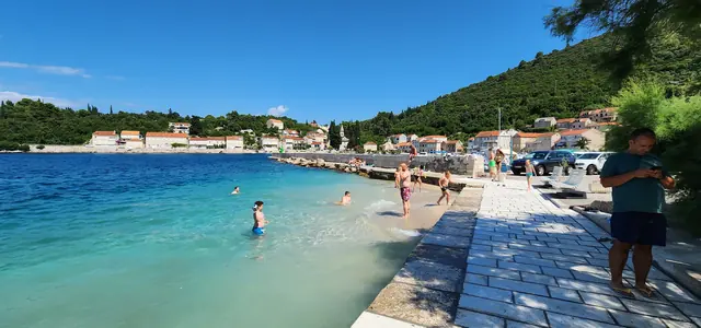 People swimming by the Račišće waterfront